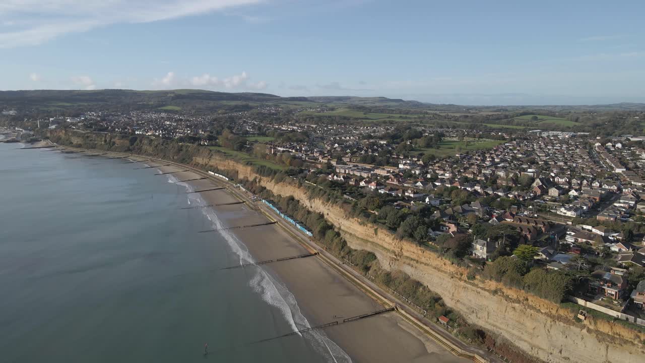 Aerial view of Sandown a seaside resort and civil parish on the south-east coast of the Isle of Wight, England. Drone rotating to the left over the beach showing the extension of sandown town
