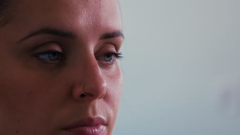primer plano de una hermosa mujer caucásica milenaria que desliza lentamente una taza de café o té por la mañana y mira lentamente hacia arriba revelando impresionantes ojos verdes y una tez bronceada fresca