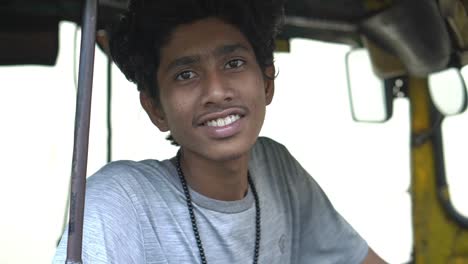 Smooth-gimble-portrait-shot-of-a-young-auto-rickshaw-driver-in-Kolkata,-West-Bengal-in-slow-motion