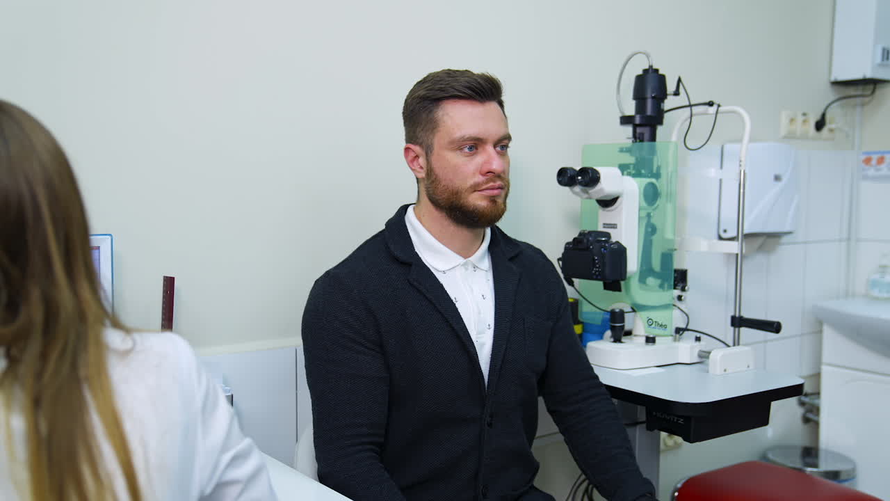 Patient during vision test. Young male patient checking up vision, closing his eye