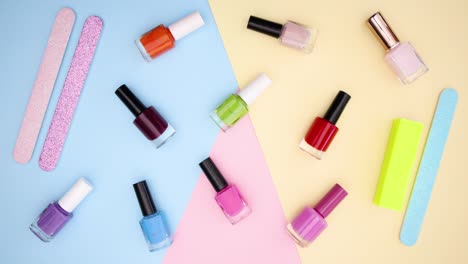 nail polishes and nail files moving on colored background - stop motion