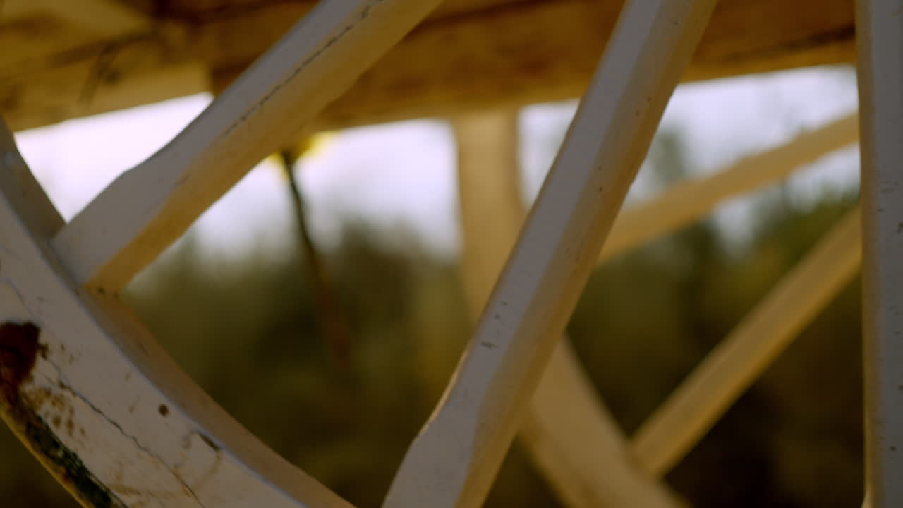 Close-up of a traditional wooden wheel bathed in golden light on the Rocío trail