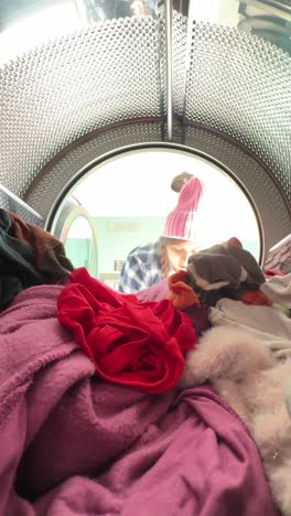 persona que carga ropa en la lavadora