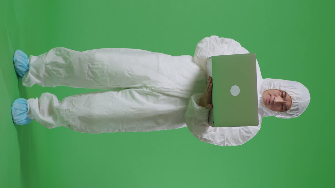 cuerpo lleno de científico masculino asiático escribiendo en una computadora portátil en un fondo de pantalla verde