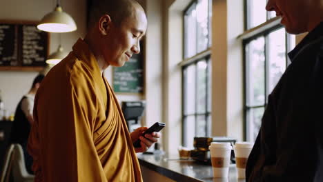 persona que utiliza un teléfono inteligente en un café