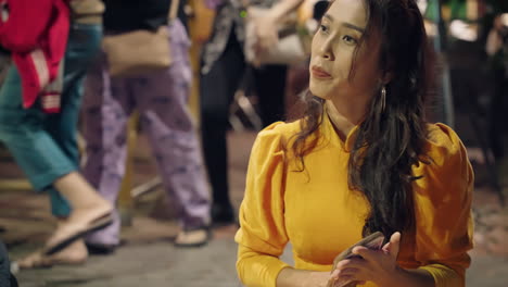 Young-Vietnamese-woman-clapping-with-wooden-paddle-playing-traditional-Bai-Choi-game-in-Hoi-An