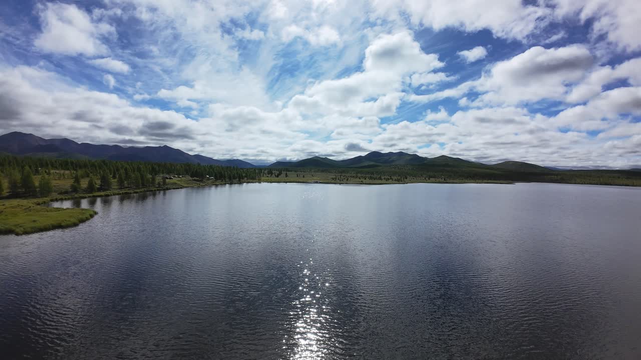 Experience the tranquility of a beautiful lake surrounded by mountains under dynamic clouds