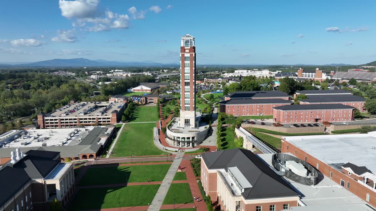 Freedom tower of liberty university with car park and apartment complex for students. Grass on campus in summer season. Aerial establishing shot