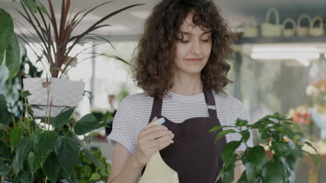 woman spraying plants in a flower shop