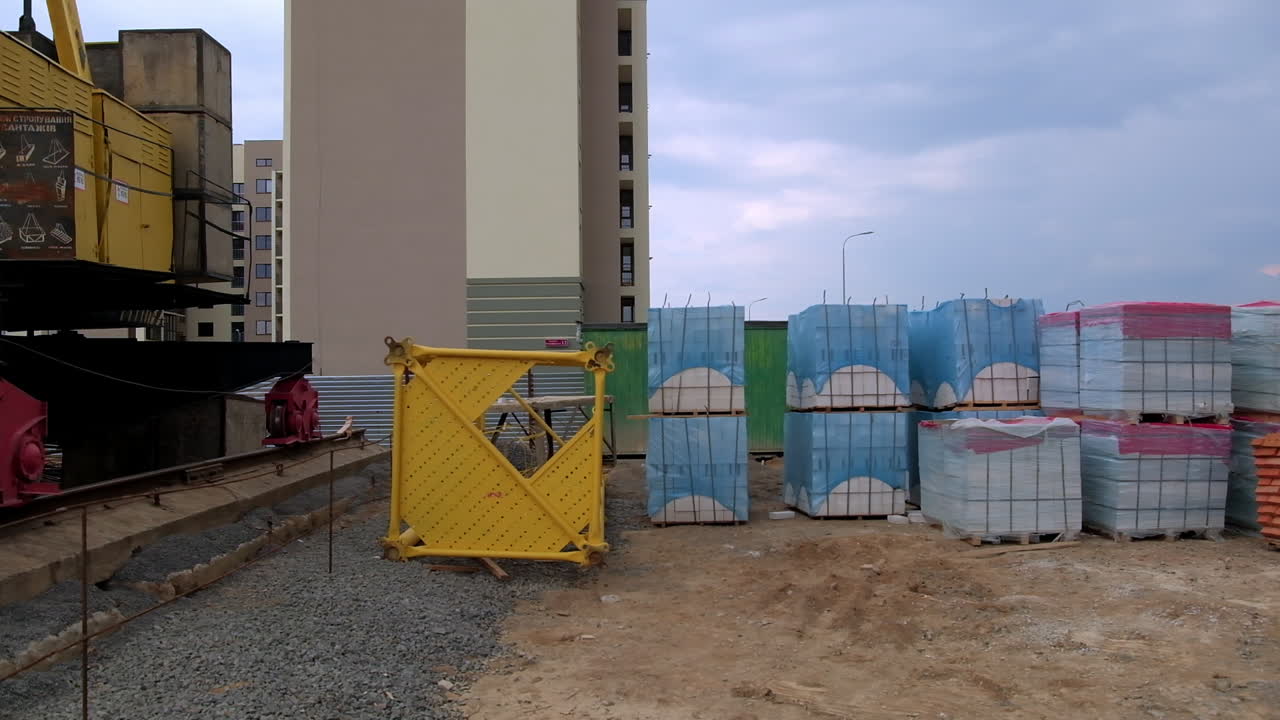 строительная площадка с краном и строительными материалами