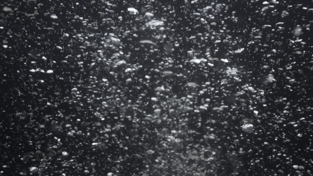 Underwater bubbles mayhem on Black Backgrounds. Illuminated bubbles motion. Ocean floor bubbles. Real underwater footage. Deep under sea level. Marine background VFX element.