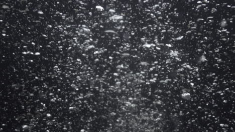 underwater bubbles mayhem on black backgrounds. illuminated bubbles motion. ocean floor bubbles. real underwater footage. deep under sea level. marine background vfx element.