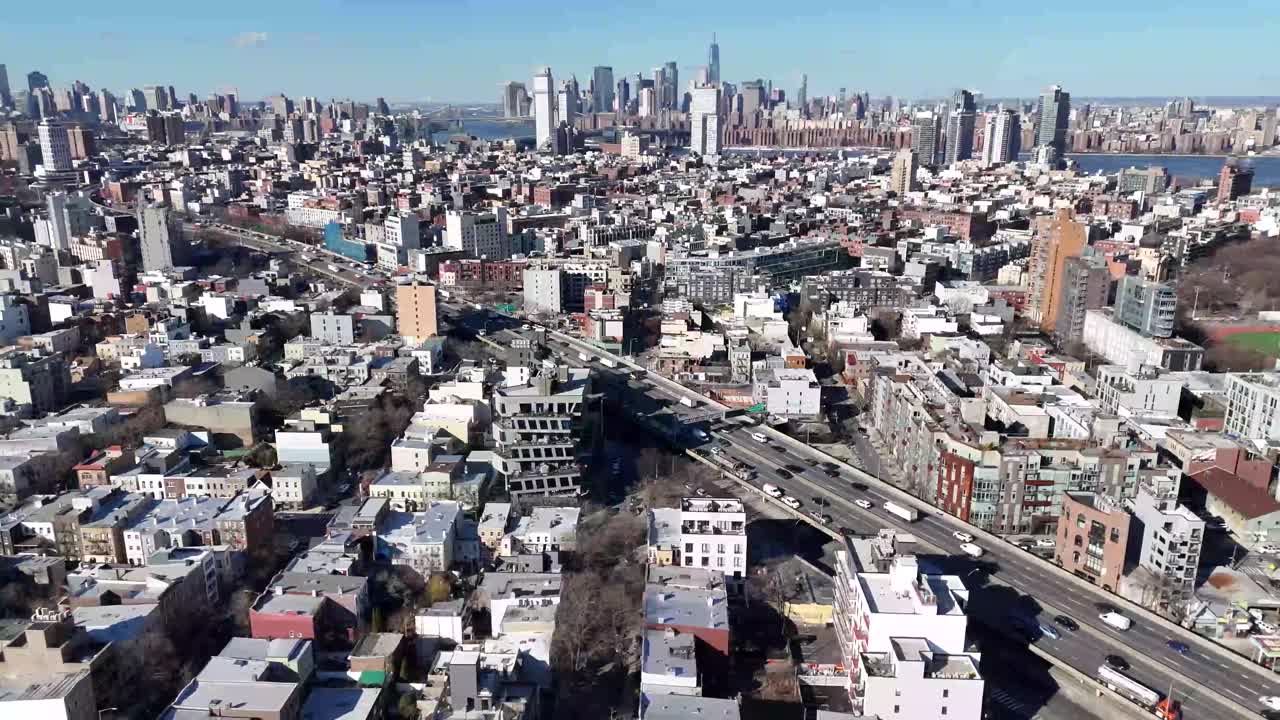 Horizontal drone arc shot over Withers Street in Brooklyn, capturing the city's vibrant streets, residential buildings, and dynamic urban skyline with a smooth, sweeping aerial motion.