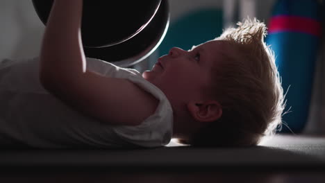 Strong-little-boy-tries-to-lift-heavy-barbell-as-adult-in-gym