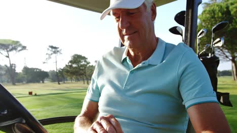 Golfer-sitting-in-golf-buggy-wearing-golf-glove