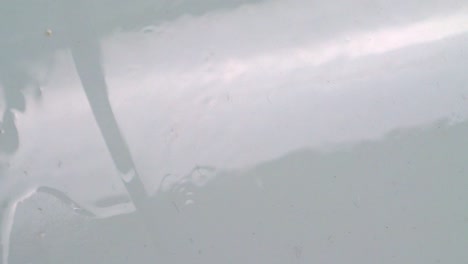 Transparent-Liquid-Dripping-On-White-Surface.-Closeup