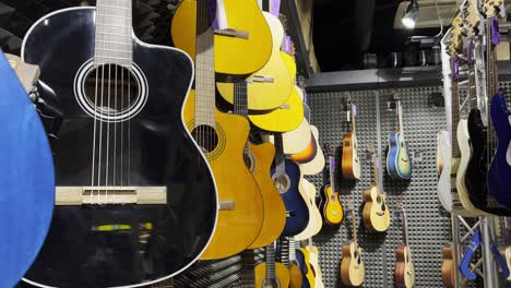 close up of multicolored acoustic guitars in a store. stringed musical instruments.