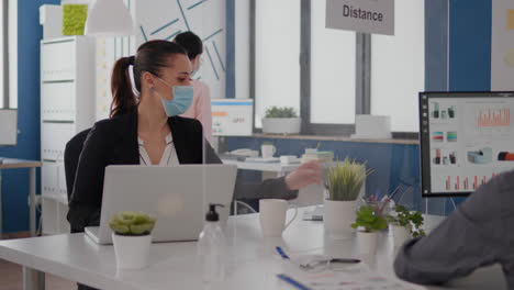 coworkers with protection face masks working together in new normal office