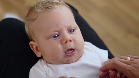 lovely caucasian fair-haired child with big blue eyes. close up portrait. baby showing tongue to parent.