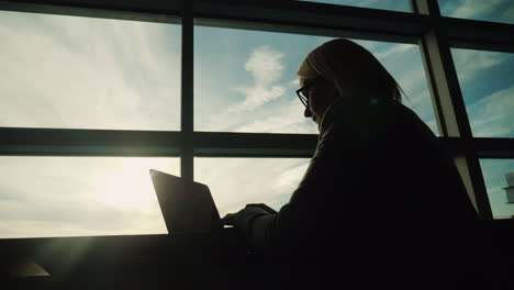 business woman working by large window