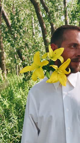 man with yellow lilies in a forest