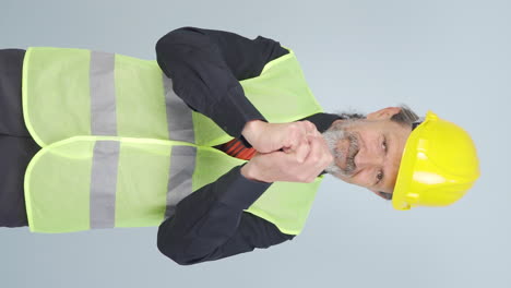 Vertical-video-of-Old-engineer-making-a-sign-of-confidence-at-the-camera.