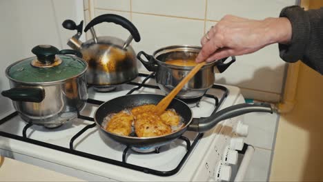 la abuela o la madre gira las chuletas de cerdo