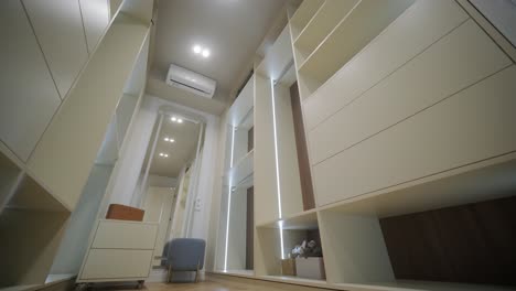 a bright and airy walk-in closet with custom shelving and a cozy seating area reflected in a full-length mirror
