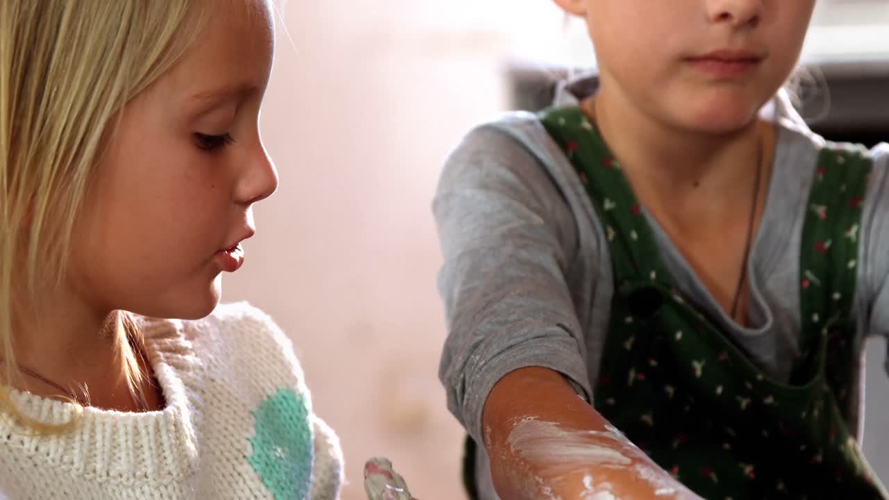 dos hermanas hablando entre sí mientras hacen una olla