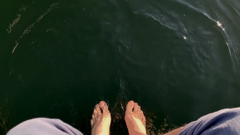 first-person perspective view of relaxing feet on the lake water