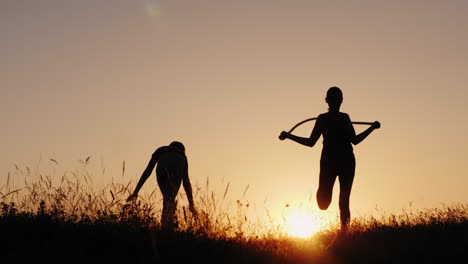 training in the fresh air - a silhouette of a woman jumping over a rope at sunset