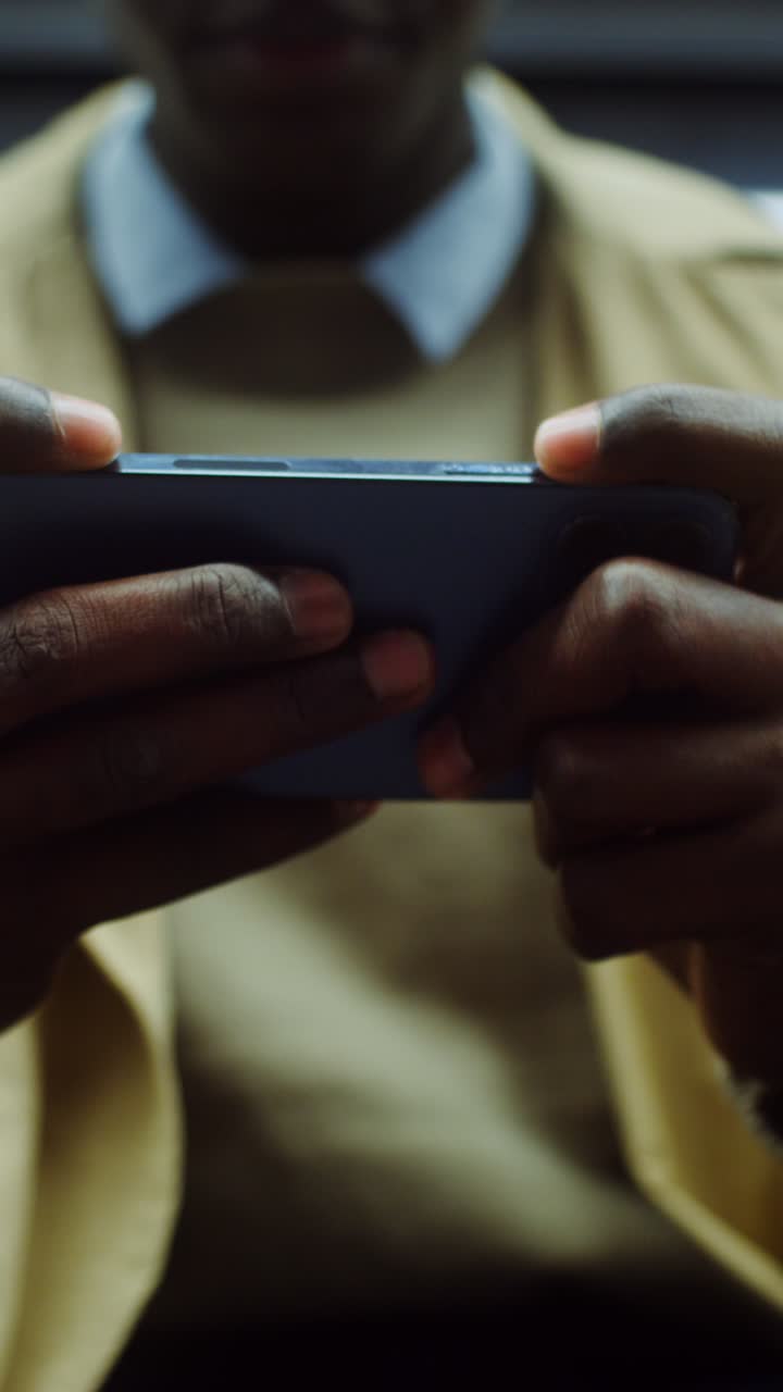 Man Playing Mobile Game on Smartphone with Headphones