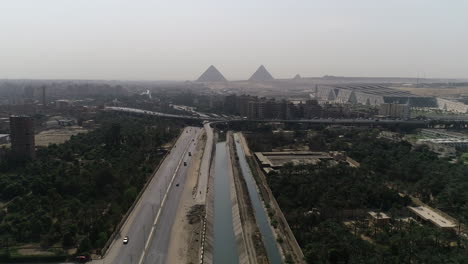 toma aérea de las pirámides de egipto en giza en el fondo de una rama del río nilo en el primer plano de la rama de maryotya