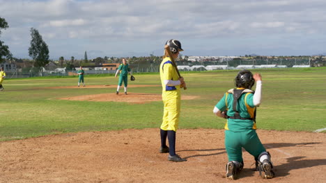 multiracial female baseball players, catching, throwing and hitting the ball on a pitch