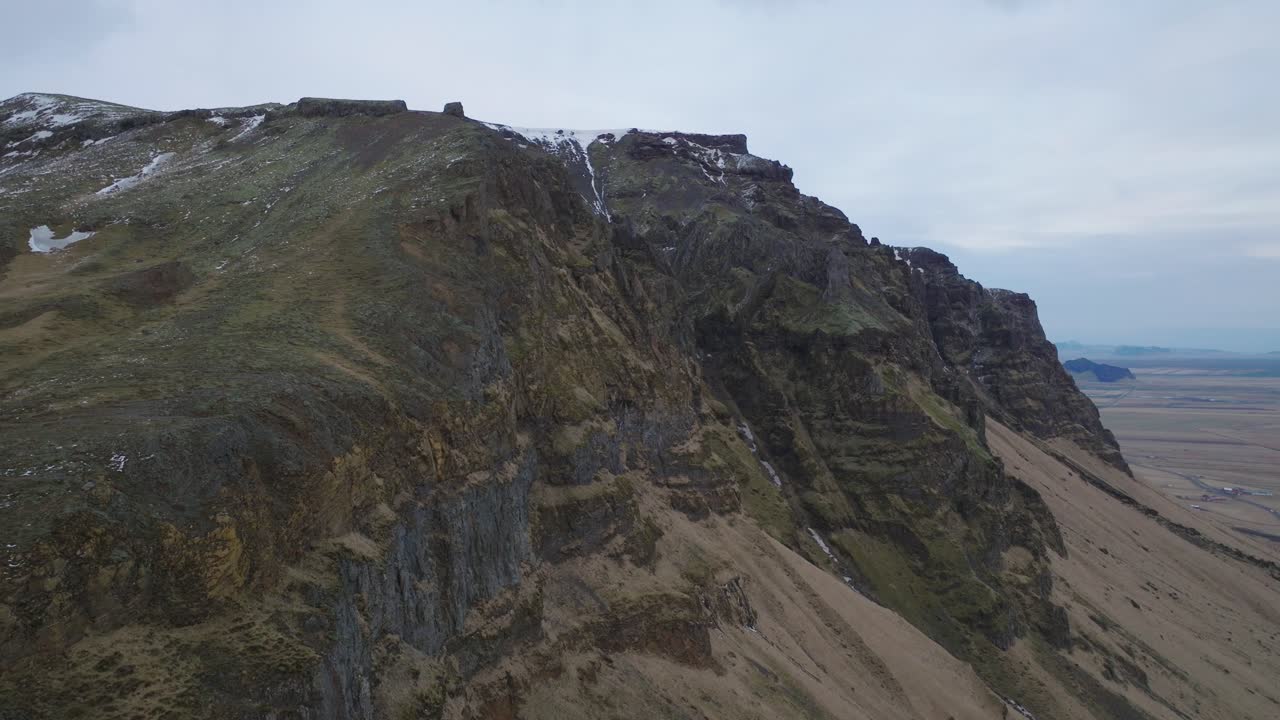 vista aérea del paisaje de las cimas de las montañas de islandia, con la nieve derretida, en una noche de mal humor