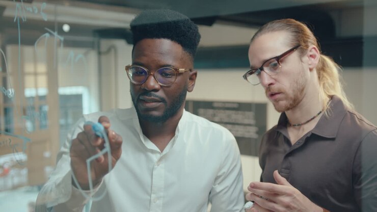 Two Businessmen Discussing Financial Diagram on Glass Office Wall