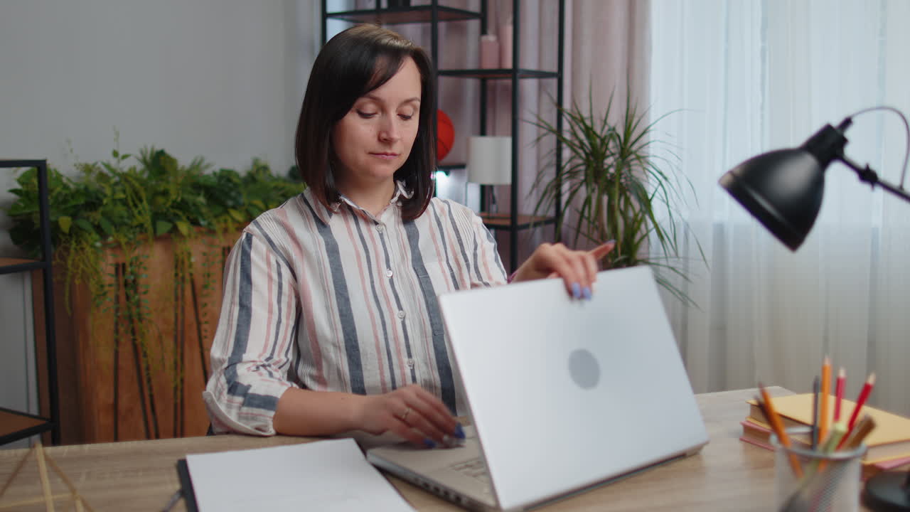 Young woman businesswoman sitting at home office closing laptop pc after finishing work, e-learning