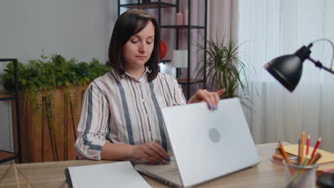 Junge-Geschäftsfrau-Sitzt-Im-Heimbüro-Und-Schließt-Den-Laptop-PC-Nach-Beendigung-Der-Arbeit,-E-Learning