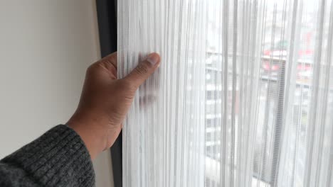 persona abriendo una cortina blanca
