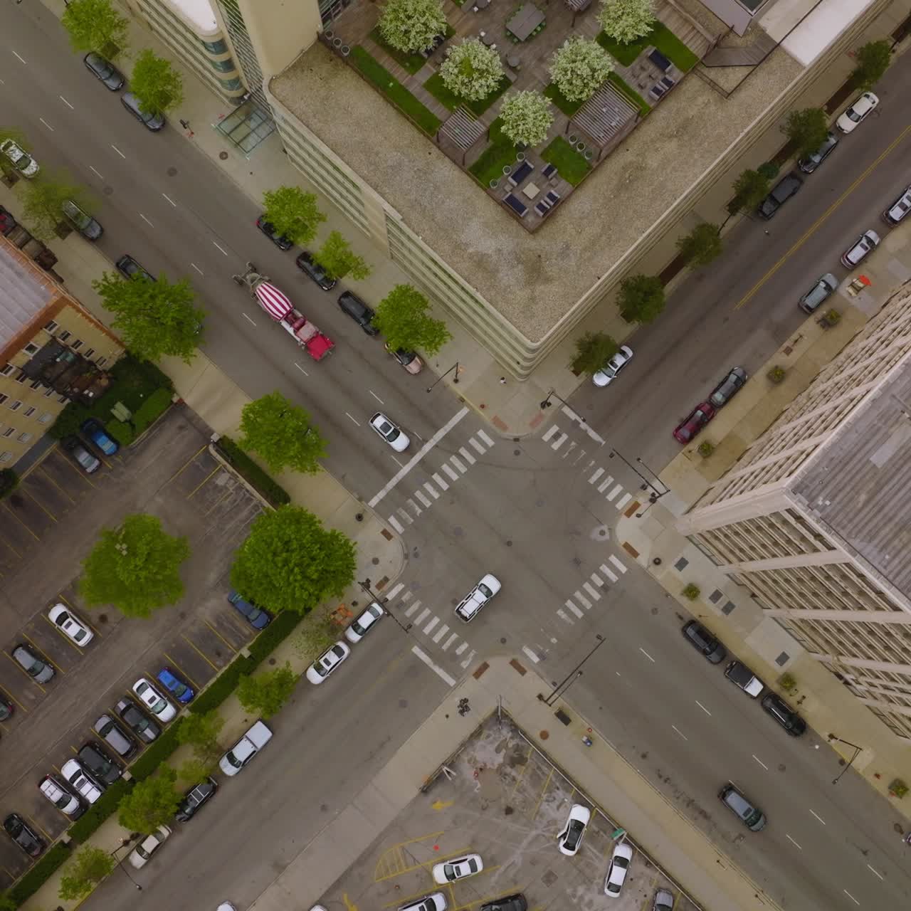 Cars crossing the crossroads in the Chicago downtown. View of the city roofs and parking lots from top at day time