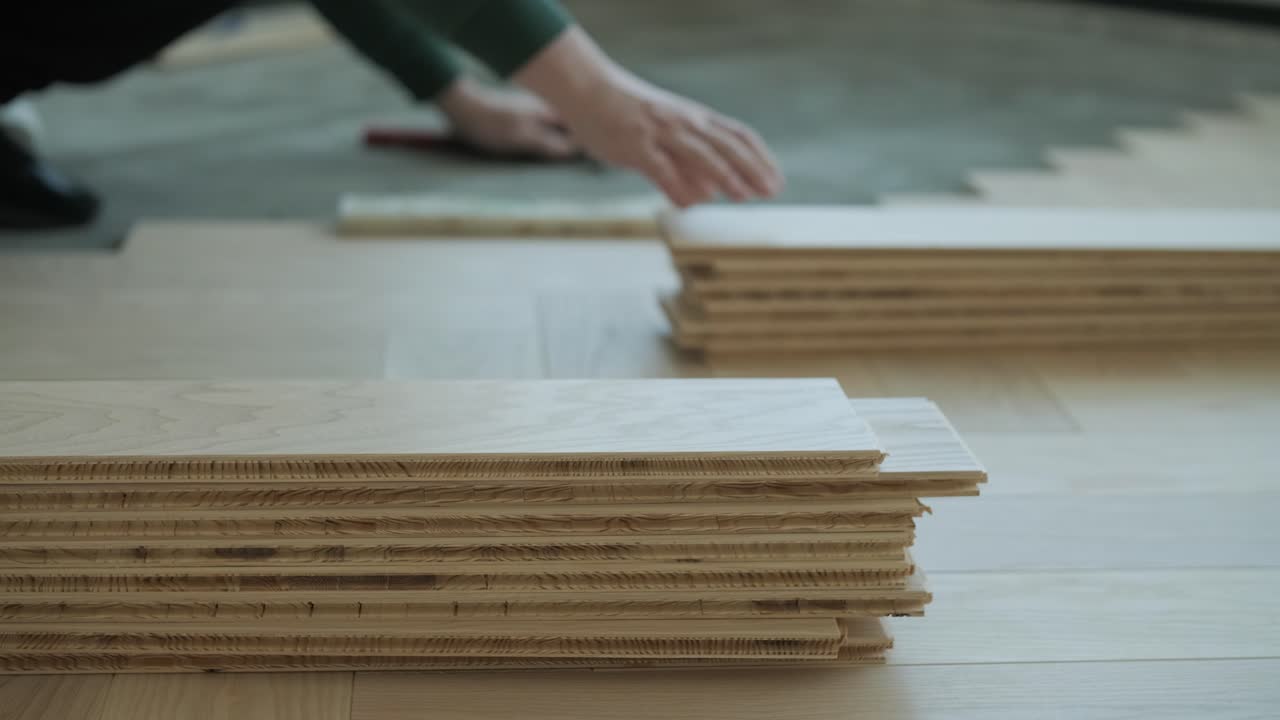 trabajador instalando pisos de madera con martillo y bloque de golpeo