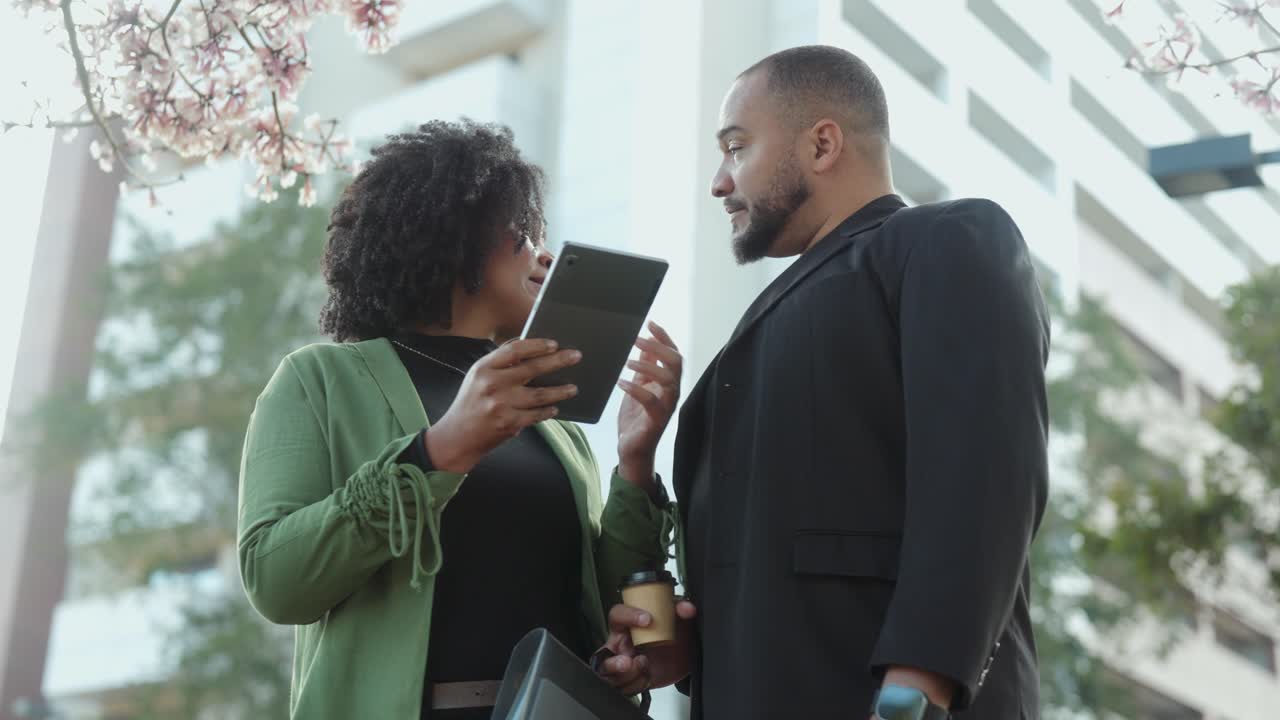 Two Business People Collaborating with a Tablet Outdoors