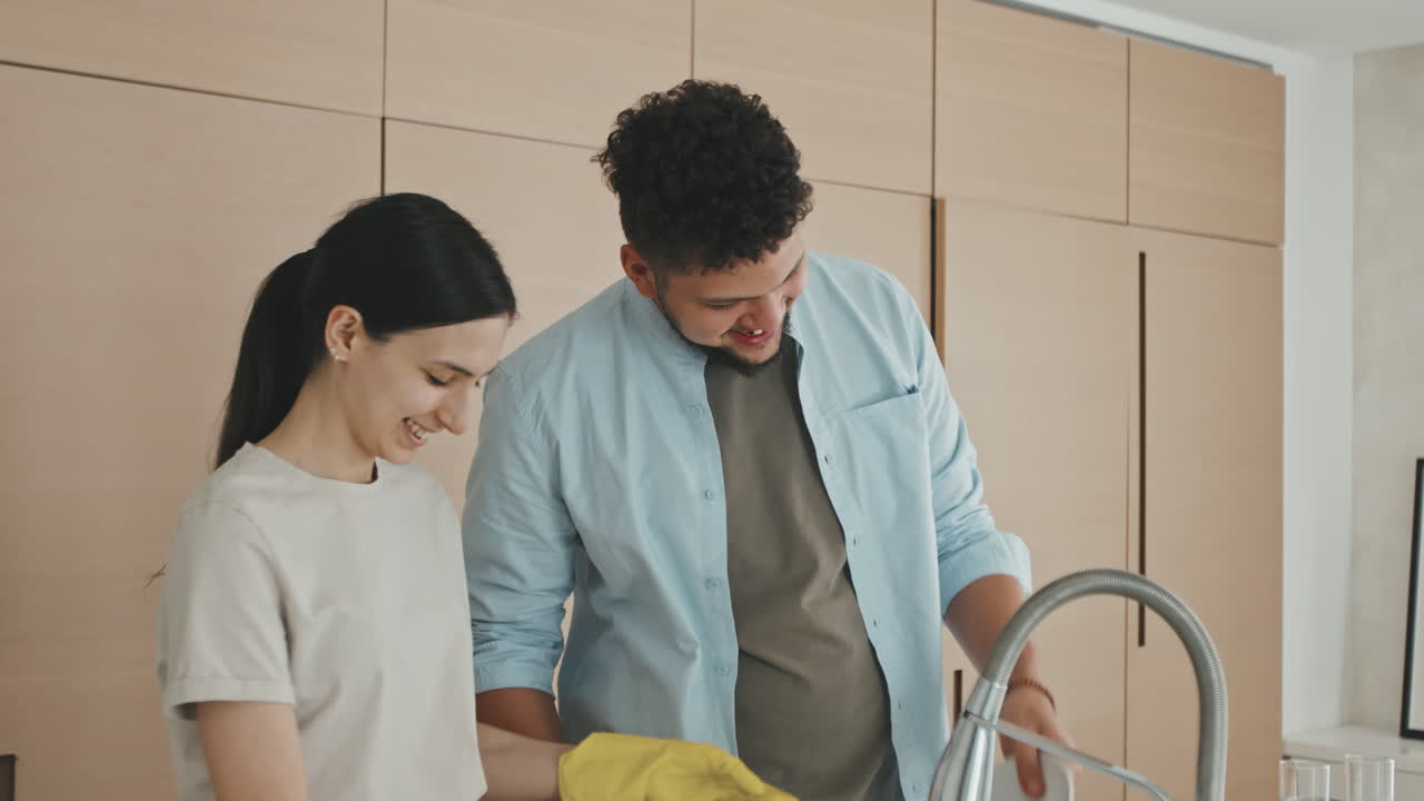Loving Young Couple Washing Dishes Together