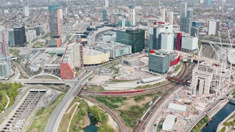 panorámica de dolly hacia adelante toma de drones de dlr y tren de superficie de londres en la ciudad de stratford