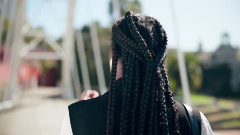 stylish african-american woman walking on a bridge