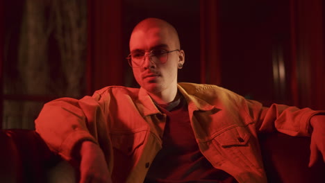 man in orange jacket under red light