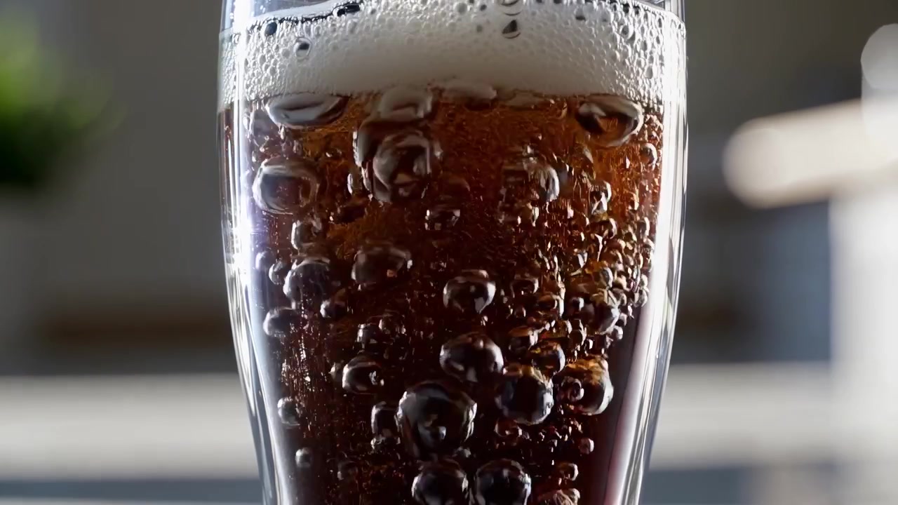 Rinfrescante bevanda scura gassata versata in un bicchiere