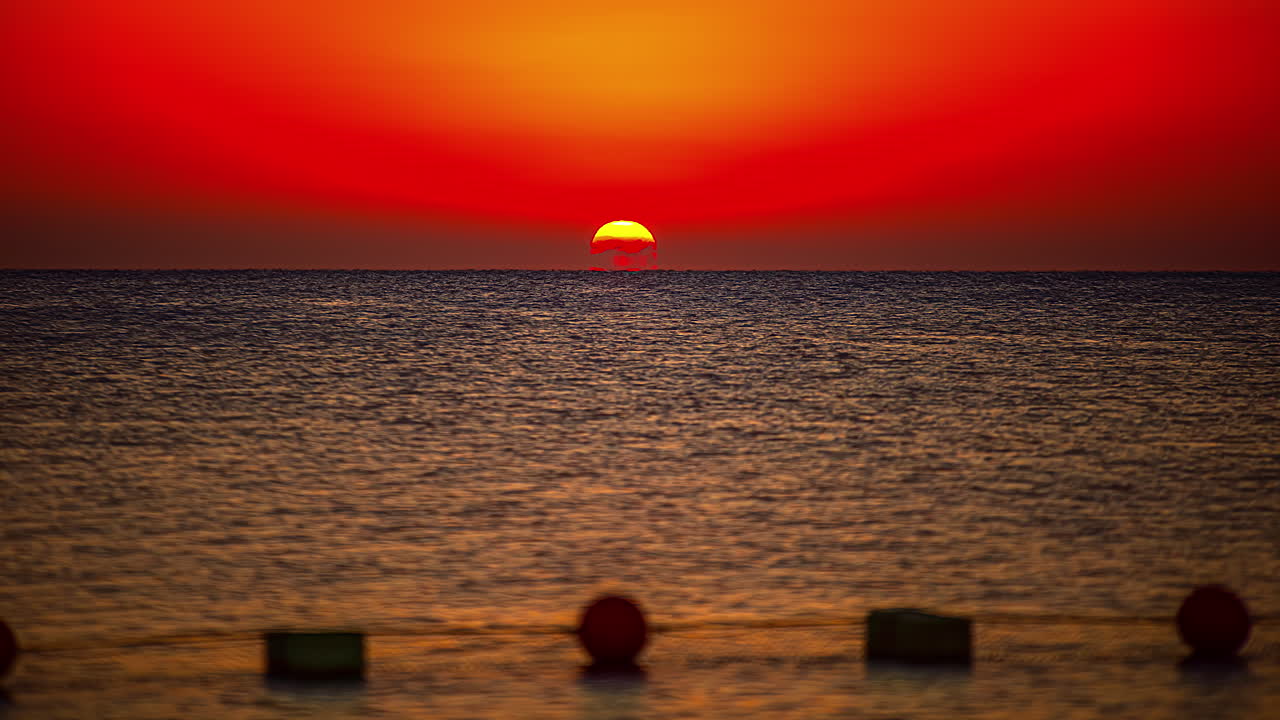 붉은 태양이 홍해의 수평선 위로 나타납니다 - 장엄한 일출 시간 경과