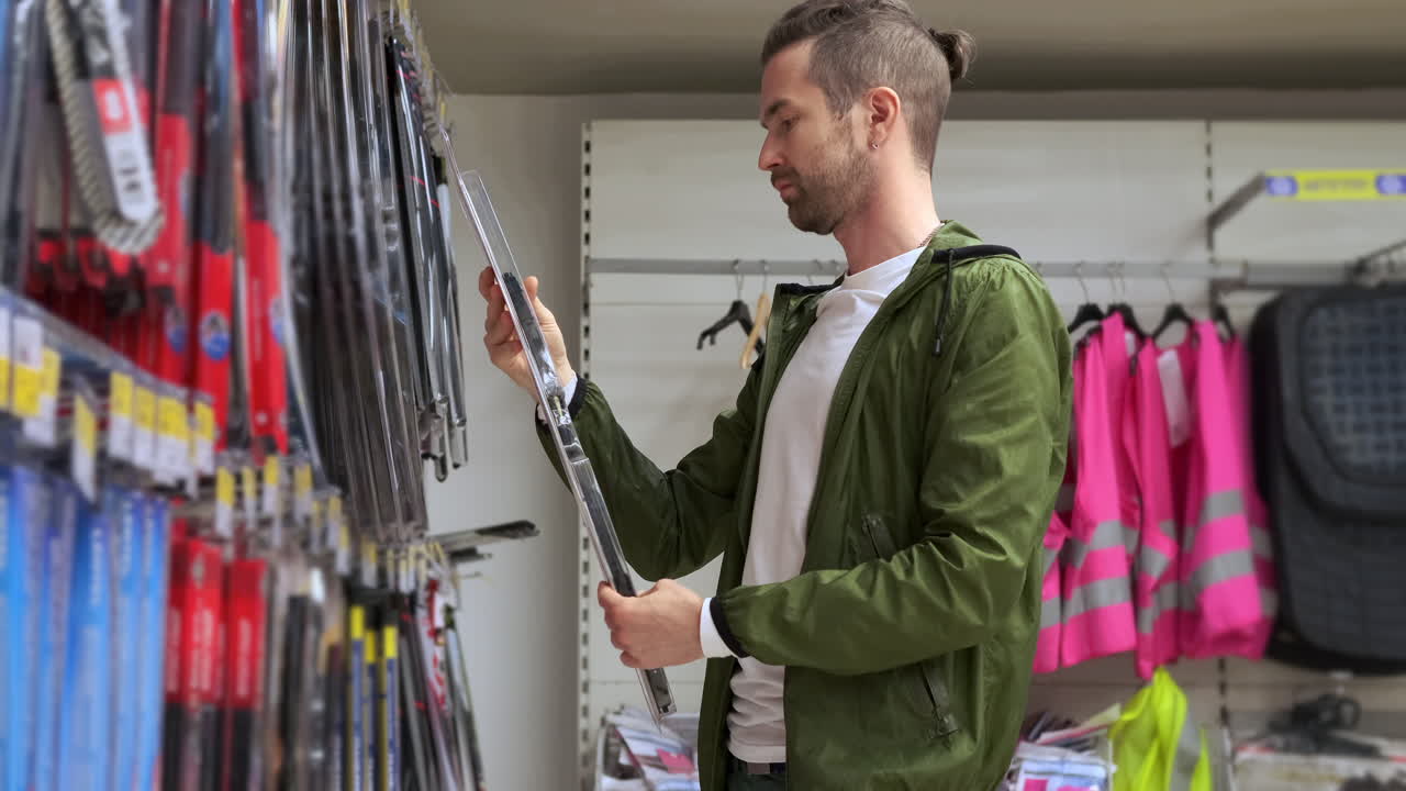 hombre comprando limpiadores de parabrisas de automóviles en una tienda de piezas de automóviles