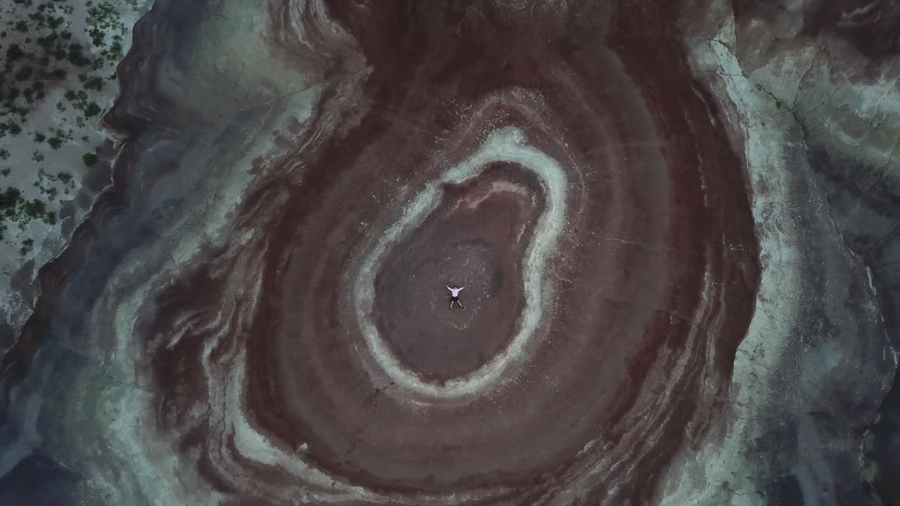 미국 행크스빌 근처 유타 사막의 사암 언덕 위에 누워 있는 남자의 하향식 공중 전망